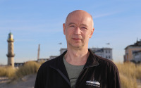 Prof. Dr. Helge Arz am Strand von Warnemünde mit Warnemünder Leutturm im Hintergrund