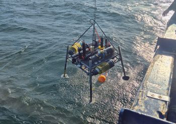 Ein Lander mit verschiedenen Sensoren wird von einem Forschungsschiff ins Wasser abgesenkt, um Messungen am Grund der Ostsee durchführen zu können.